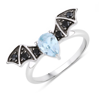 front angled view of bat wing ring with pear sky blue topaz center and black spinel accents in dual tone rhodium over sterling silver