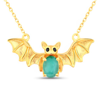 front centered view of bat necklace with oval emerald body and black spinel eyes in 18k yellow gold over sterling silver