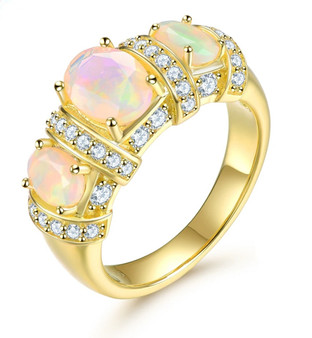 ethiopian opal and white zircon trilogy ring in 18k yellow gold over sterling silver shown in a lifestyle photo
