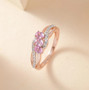 pink sapphire and zircon trilogy bypass ring in 18k rose gold over sterling silver shown in a lifestyle photo