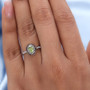 sphene with white and brown zircon halo ring in rhodium over sterling silver worn on a hand