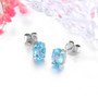 blue apatite 7x5mm oval stud earrings in solid 14k white gold shown in a lifestyle photo