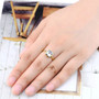 aquamarine and emerald cut bezel set solitaire ring in solid 18k yellow gold worn on a hand