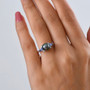 tahitian pearl tanzanite and moissanite three stone ring in rhodium over sterling silver worn on a hand
