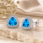 fancy cut trillion swiss blue topaz and moissanite halo stud earring in rhodium over sterling silver live studio