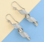 rhodium over sterling silver swirl sparkle dangle earrings in rhodium over sterling silver shown in a lifestyle photo
