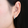 aquamarine huggie hoop earrings in rhodium over sterling silver worn on the ear
