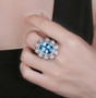 swiss blue topaz and diamond ring in 14k white gold worn on a hand