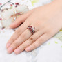 garnet leaf cluster ring in rhodium over sterling silver worn on a hand