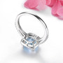 close up of sky blue topaz and zircon square cushion halo ring in rhodium over sterling silver