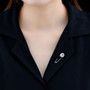swiss blue topaz and white zircon safety pin brooch in rhodium over sterling silver shown being worn