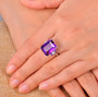 amethyst and emerald cut and diamond ring in 14k white gold worn on a hand