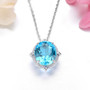 close up of swiss blue topaz and white zircon halo pendant necklace in rhodium over sterling silver