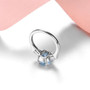 close up of sky blue topaz and white zircon 3 stone ring in rhodium over sterling silver