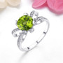 peridot and white zircon bow ring in rhodium over sterling silver shown in a lifestyle photo