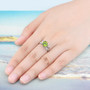 peridot and white zircon bow ring in rhodium over sterling silver worn on a hand