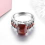 sugarloaf cut hessonite garnet and white zircon ring in rhodium over sterling silver shown in a lifestyle photo