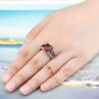 sugarloaf cut hessonite garnet and white zircon ring in rhodium over sterling silver worn on a hand