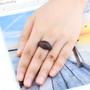 domed garnet band ring in black and white rhodium over sterling silver worn on a hand