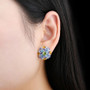peridot swiss blue topaz tanzanite citrine and zircon cluster stud earrings in rhodium over sterling silver worn on the ear
