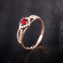 side view of ruby and diamond infinity design ring in 14k rose gold