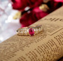 ruby and diamond open work ring in 14k yellow gold shown in a lifestyle photo