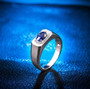mens sapphire and diamond halo ring in 14k white gold shown in a lifestyle photo