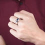 mens sapphire and diamond halo ring in 14k white gold worn on a hand