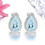 aquamarine and diamond pear halo earrings in 14k white gold shown in a lifestyle photo