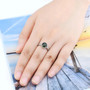 chrome diopside and white zircon round halo ring in rhodium over sterling silver worn on a hand