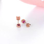 close up of unheated ruby oval bezel set stud earrings in 14k rose gold