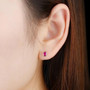 unheated ruby oval bezel set stud earrings in 14k rose gold worn on the ear