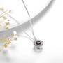 close up of dancing garnet and zircon round double halo pendant necklace in rhodium over sterling silver