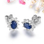 side view of sapphire and white zircon halo stud earrings in rhodium over sterling silver