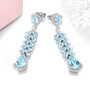 sky blue topaz and white zircon drop earrings in rhodium over sterling silver shown in a lifestyle photo