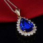 close up of tanzanite and diamond halo necklace in 14k yellow gold