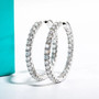 moissanite hoop earrings in rhodium over sterling silver shown in a lifestyle photo