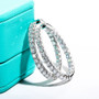 angled view of moissanite hoop earrings in rhodium over sterling silver