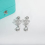 moissanite and cz fleur de lis earrings in rhodium over sterling silver shown in a lifestyle photo