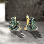 green spinel and cz frog drop earrings in 18k yellow gold over sterling silver shown in a lifestyle photo