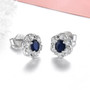 side view of sapphire and zircon oval halo stud earrings in rhodium over sterling silver