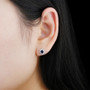 sapphire and zircon oval halo stud earrings in rhodium over sterling silver worn on the ear