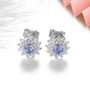 tanzanite and zircon round halo stud earrings on rhodium over sterling silver shown in a lifestyle photo