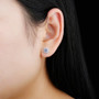 tanzanite and zircon round halo stud earrings on rhodium over sterling silver worn on the ear
