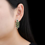 chrome diopside and white zircon dangle earrings in rhodium over sterling silver worn on the ear