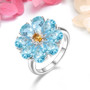 sky blue topaz and citrine halo ring in rhodium over sterling silver shown in a lifestyle photo