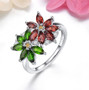 chrome diopside garnet citrine and zircon flower ring in rhodium over sterling silver shown in a lifestyle photo