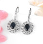 sapphire and white zircon double halo earrings in rhodium over sterling silver shown in a lifestyle photo