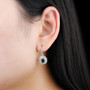 sapphire and white zircon double halo earrings in rhodium over sterling silver worn on the ear