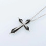 black spinel and cubic zirconia cross in black and white rhodium over sterling silver shown in a lifestyle photo
